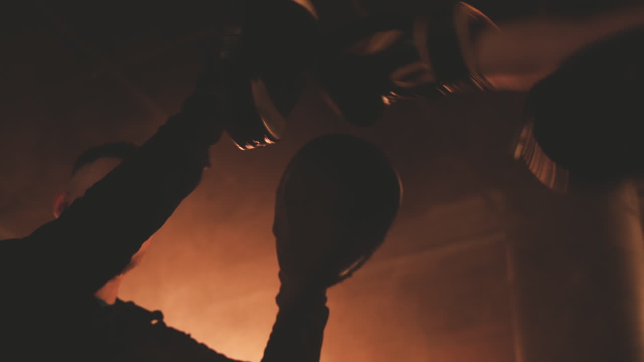 una boxeadora irreconocible golpea repetidamente los guantes de su entrenador