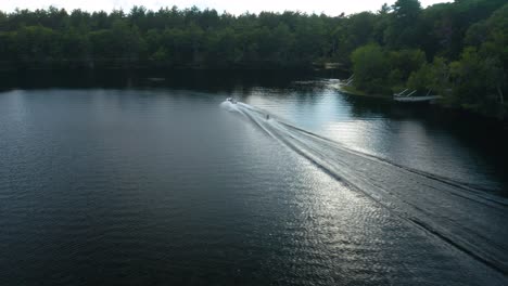 Ein-Skifahrer,-Der-Hinter-Einem-Motorboot-Gezogen-Wird,-Während-Er-An-Der-Rasanten-Aktivität-Des-Wasserskifahrens-Teilnimmt,-Bei-Der-Mit-Einem-Oder-Mehreren-Skiern-über-Die-Wasseroberfläche-Gefahren-Wird