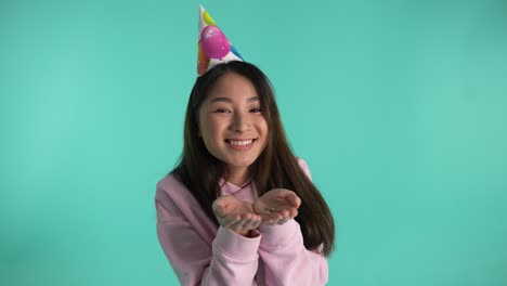 una alegre niña de cumpleaños soplando chispas de colores