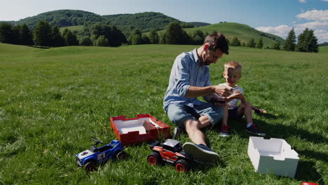 father and son assembling a toy together in a green field