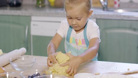 niña divirtiéndose amasando los pasteles