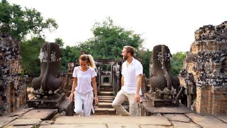 young couple contemplating ancient temple in cambodia