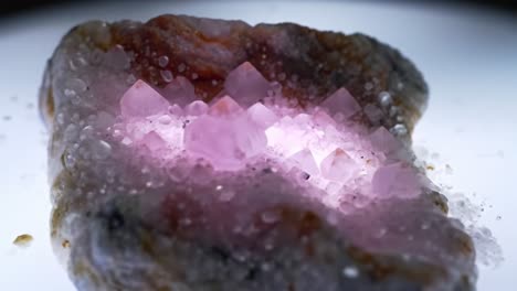a stunning display of translucent crystals illuminated by soft light, highlighting their unique formations and textures on a natural stone surface