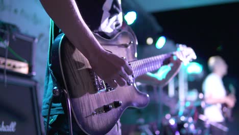 Vista-De-Cerca-De-Un-Hombre-Tocando-La-Guitarra-Eléctrica-En-El-Escenario-Del-Concierto.-Tiro-En-Cámara-Lenta