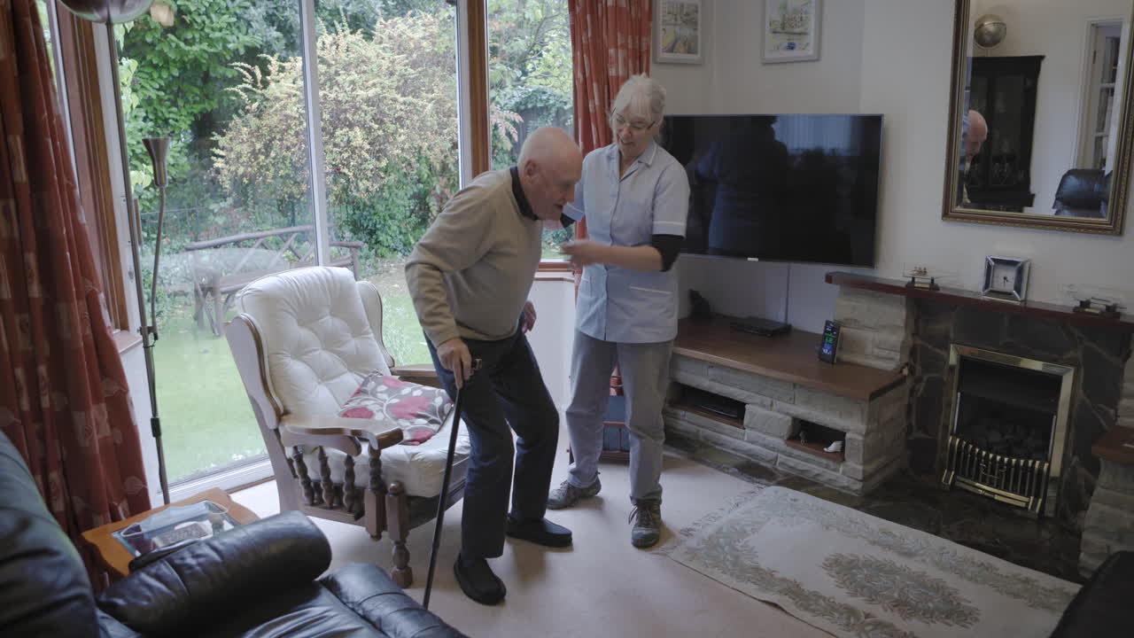 Elderly man receiving assistance from a nurse at home