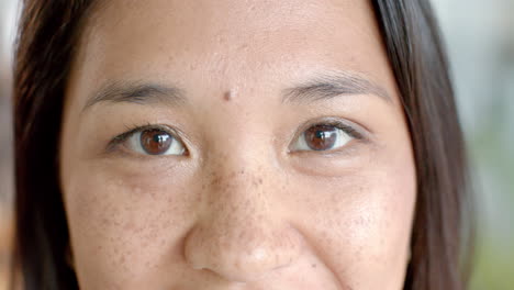 close-up of an asian woman's face, highlighting her eyes and freckles