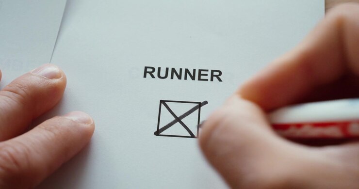 Close-up of a hand marking the runner checkbox on a paper form, representing running, fitness and active lifestyle.