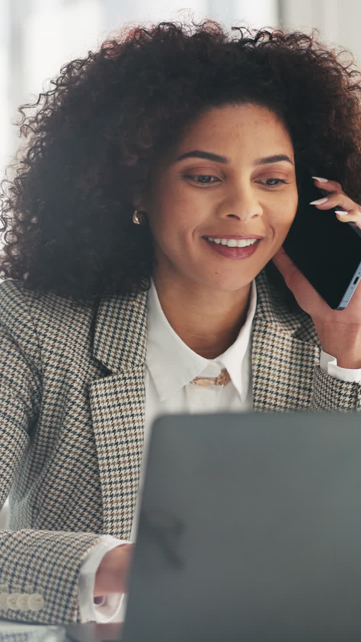 Donna professionista che parla al telefono mentre lavora al laptop.