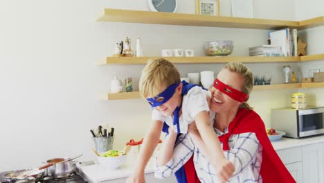 mother and son pretending to be superhero in living room 4k