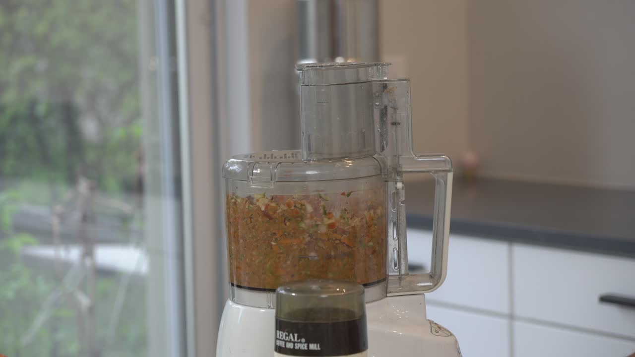 식품 프로세서 내부의 재료를 혼합하여 채식주의 버거 파테를 만들기 위해 일관성을 달성합니다.