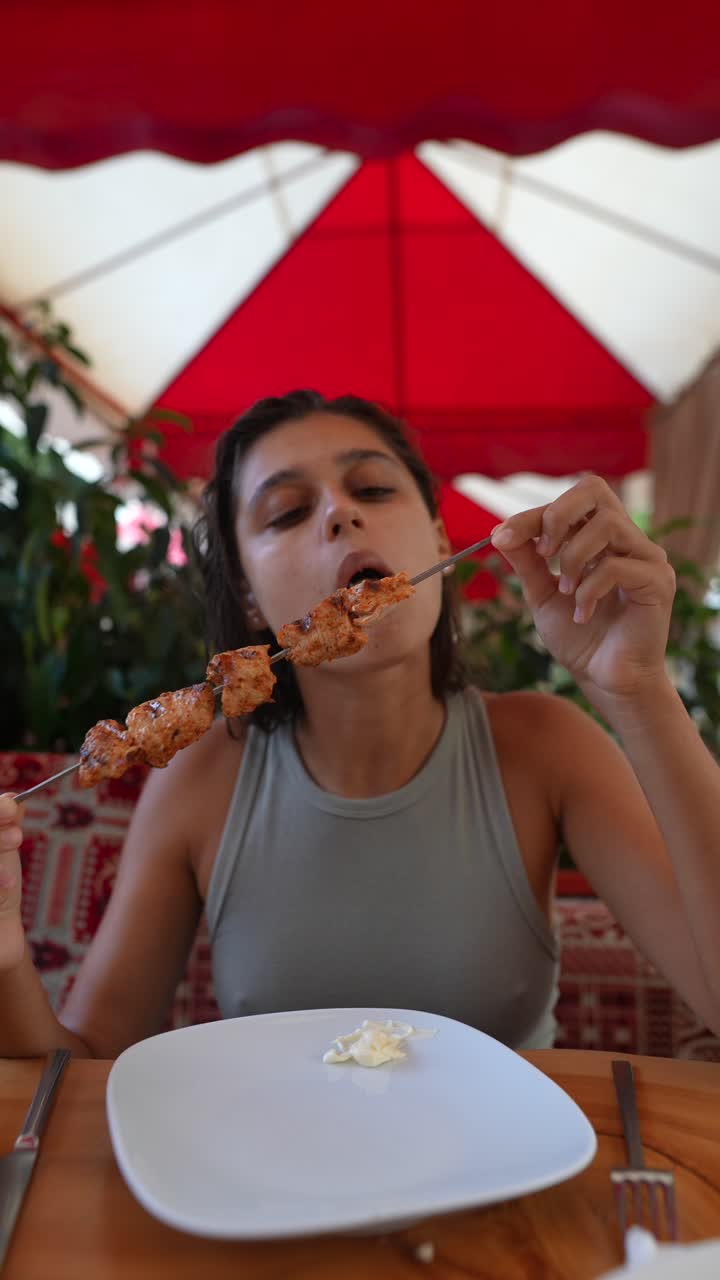 mujer comiendo kebabs al aire libre