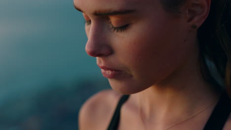 beautiful-woman-on-mountain-top-looking-at-view-of-ocean-at-sunrise-enjoying-peaceful-contemplation-with-wind-blowing-hair