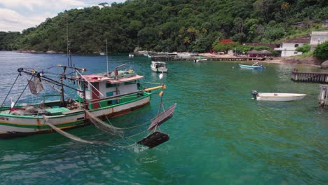 Barco-De-Pesca-Se-Balancea-En-Agua-Verde-Jade-Cerca-De-La-Costa-En-El-Mar-Rural-De-Brasil