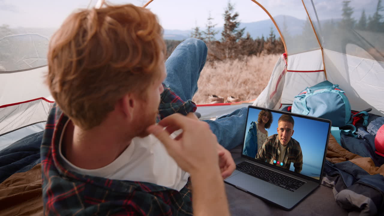 Videochiamata di persone in viaggio nell'app per conferenze. Primo piano di un ragazzo che si riposa in montagna