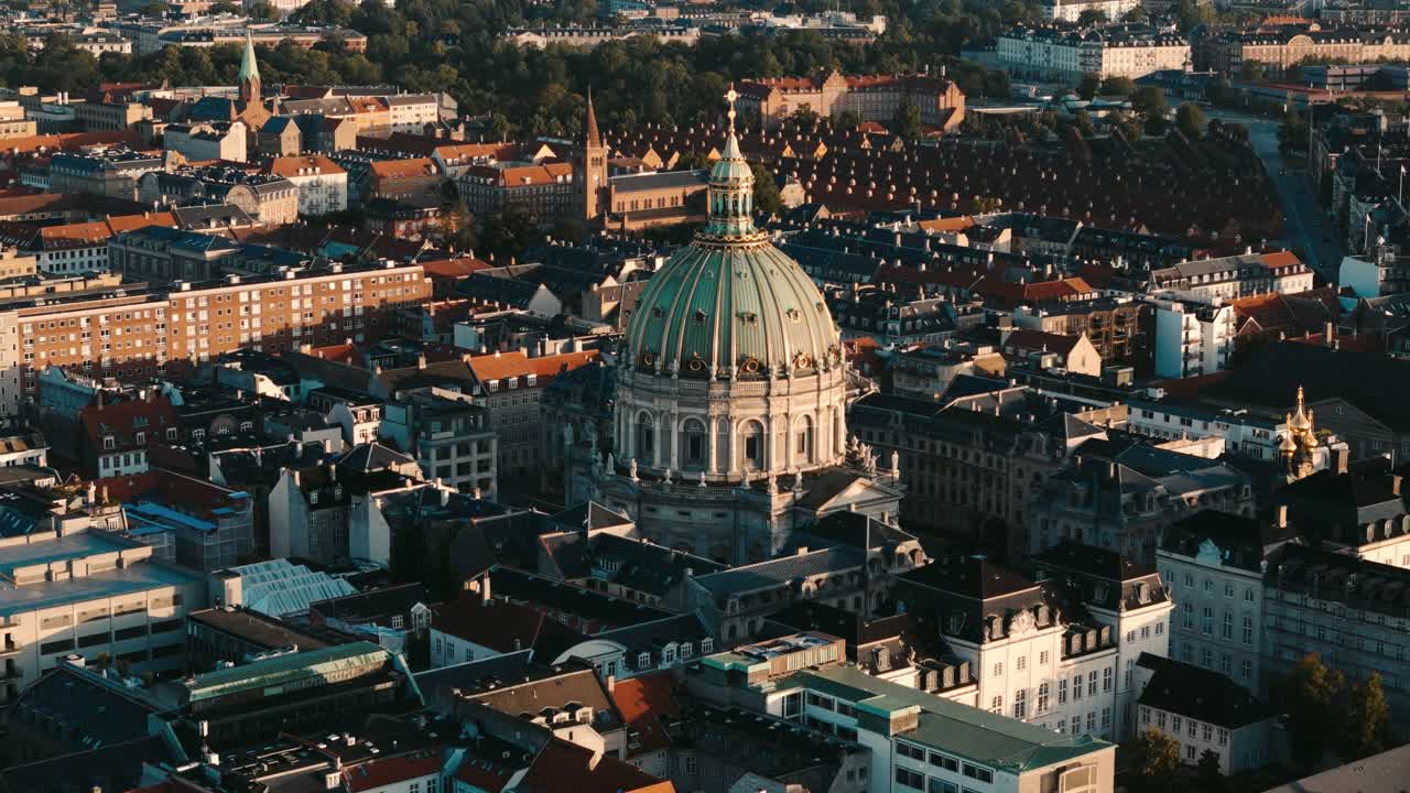 Aerial flyover of Frederiks Kirke church dome at sunrise with warm light in Copenhagen