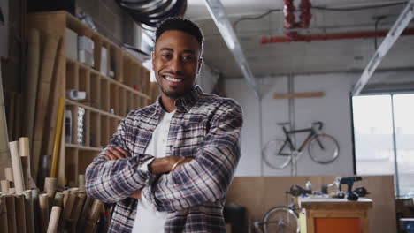 Portrait-Of-Young-Male-Business-Owner-In-Workshop-For-Building-Sustainable-Bamboo-Bicycles