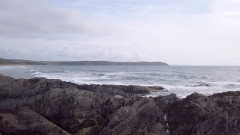 panning away from sandy beach - rocky shore to the atlantic ocean