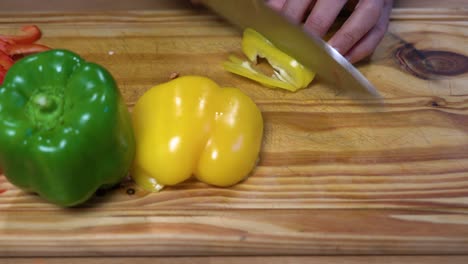 rebanar pimientos en juliana sobre tablero de madera cocina dieta sana y saludable