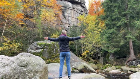 a woman enjoys the autumn nature she looks at the rocky stone mountains a feeling of connection with a woman enjoys the autumn nature she looks at the rocky stone mountains a feeling of connection with nature