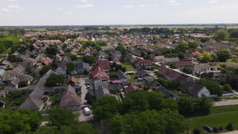 Vuelo-Aéreo-Pasando-Por-Casas-En-La-Pequeña-Ciudad-De-Batya,-Hungría,-Siguiendo-De-Izquierda-A-Derecha