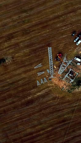 construction site of high voltage power lines in agricultural fields, aerial vertical view