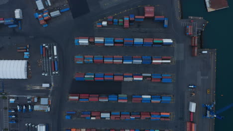 Aerial-birds-eye-overhead-top-down-view-of-stacked-containers-in-harbour.-Rows-of-various-colour-containers-for-overseas-shipping.-Logistics,-import-and-export-concept.-Reykjavik,-Iceland
