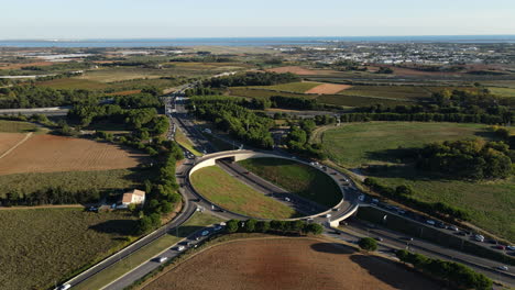 Vista-Aérea-De-Una-Destacada-Rotonda-En-Montpellier,-Enmarcada-Por-Un-Exuberante-Campo-Verde.