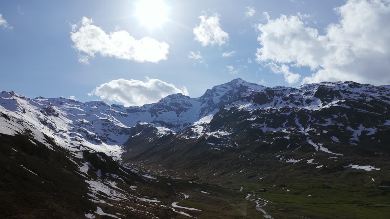 A vibrant alpine landscape displaying snow-covered mountains under clear skies.