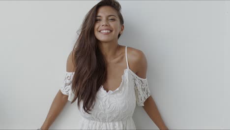 Happy-young-woman-in-white-dress-looking-at-camera