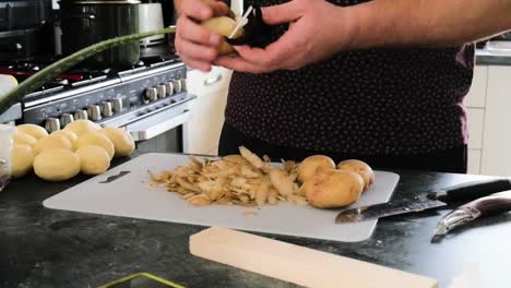 el hombre pela sus papas para la cena familiar