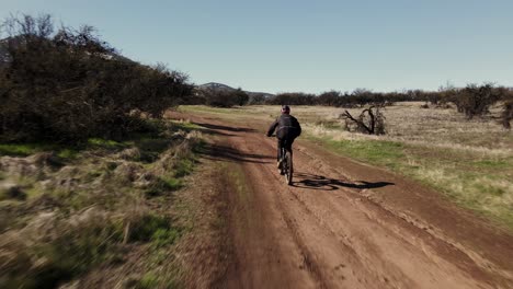 Toma-De-Seguimiento-De-Un-Ciclista-De-Montaña-En-Un-Parque-De-Bicicletas,-Antena-Uhd-4k