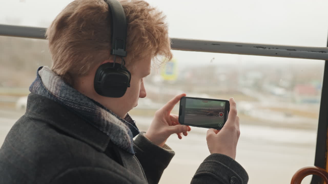 Un fotografo di città registra momenti dello skyline. Un individuo filma il paesaggio urbano dall'autobus durante le condizioni meteorologiche. Un individuo creativo cattura lo skyline della città attraverso il finestrino dell'autobus in condizioni di viaggio nuvolose.