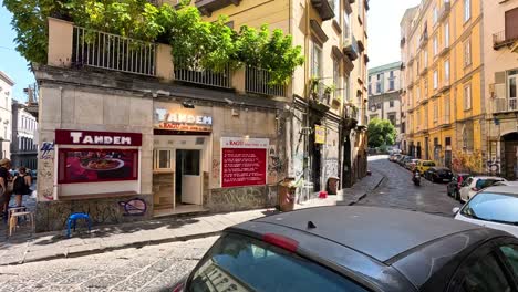 people walking and cars on a narrow street