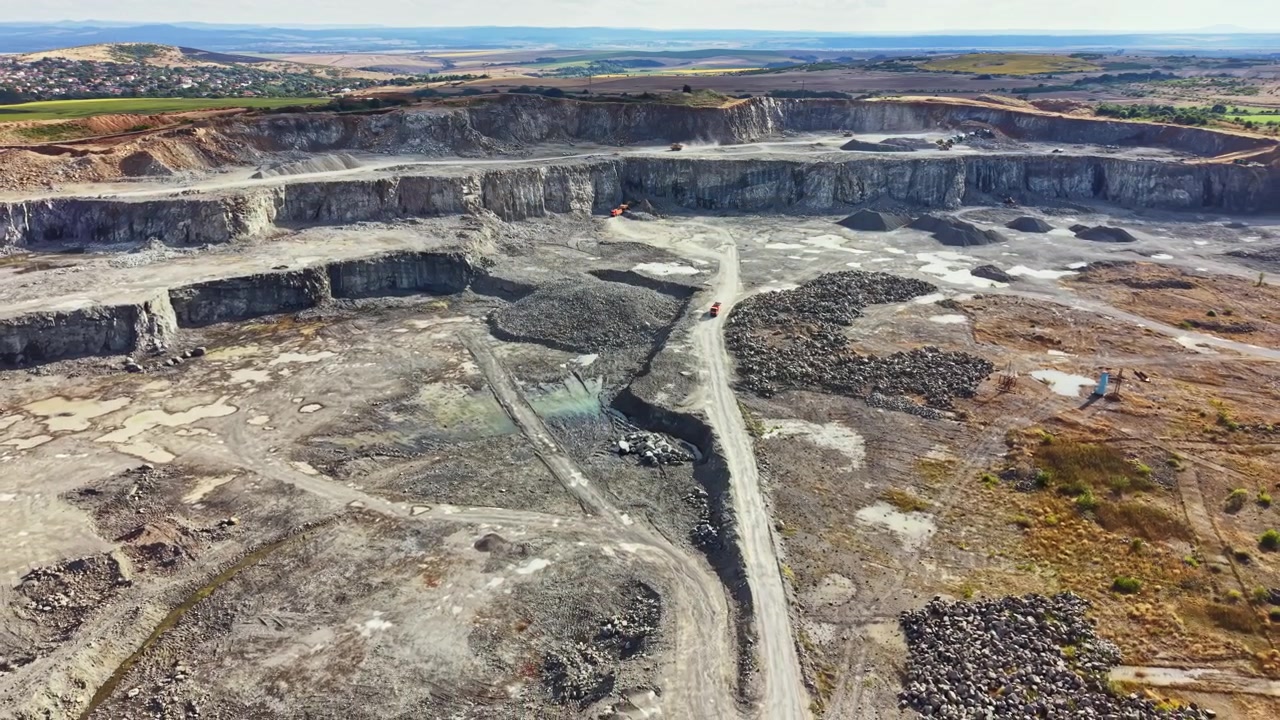 Large granite quarry with machinery and exposed rock formations during daytime