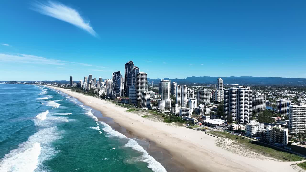Un drone scivola sopra le splendide spiagge della Gold Coast, catturando onde turchesi scintillanti, sabbie dorate e surfisti che si godono una perfetta giornata estiva sotto il brillante sole australiano.