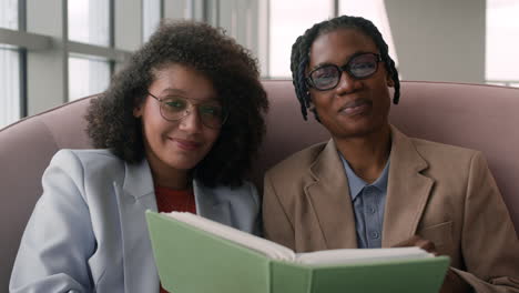 two women reading together in a modern cafe