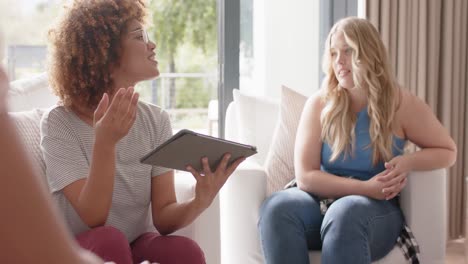 amigos diversos hablando y usando tableta en terapia de grupo, cámara lenta