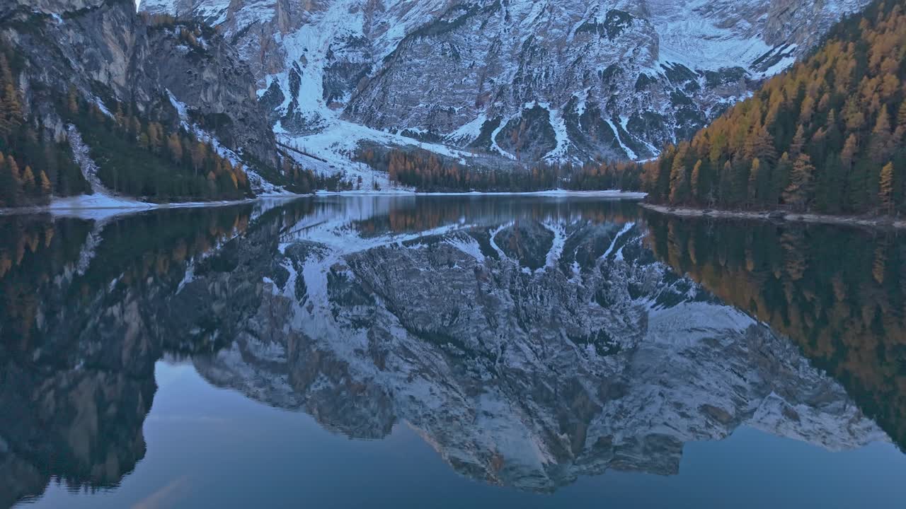 Lago di Braies surrounded by fall colors, aerial view, Italian Alps