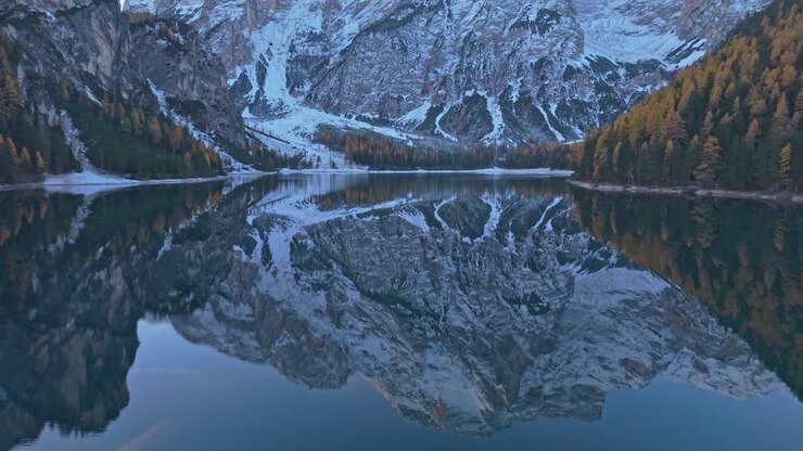 Lago di Braies circondato dai colori autunnali, vista aerea, Alpi italiane
