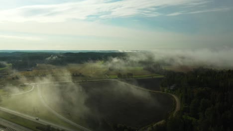 vista aérea estática de la niebla matutina flotando sobre una carretera de 4 carriles con automóviles y camiones