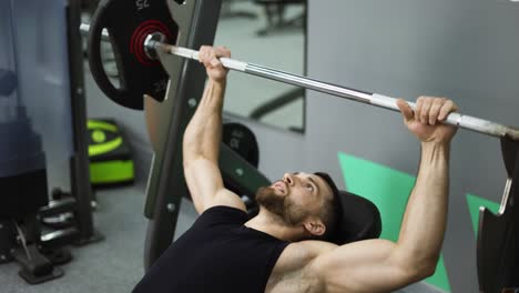 Hombres-Acostados-Y-Haciendo-Ejercicio-En-Press-De-Banca-Con-Barra-En-El-Gimnasio