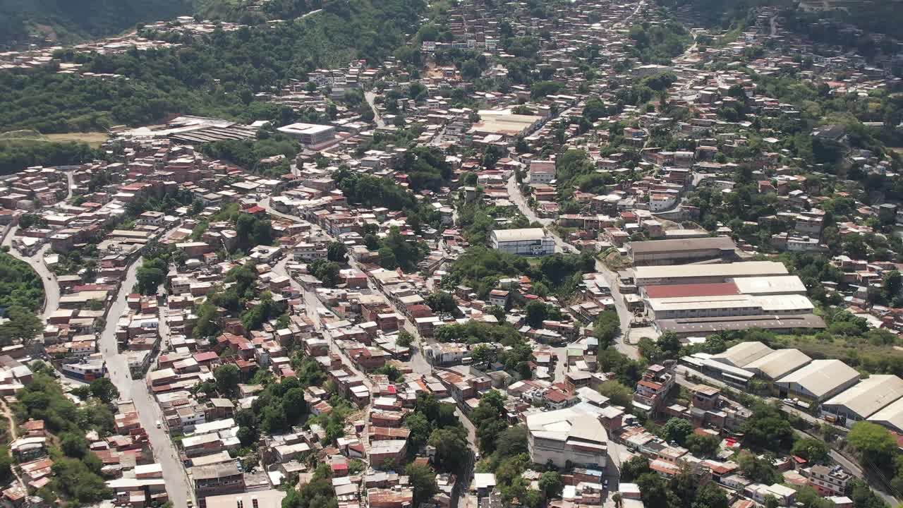 Zona industriale a Guarenas, Miranda, circondata da colline e case, vista aerea