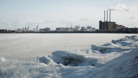 Frozen-sea-on-coast-city-in-cold,-sunny-winter-day