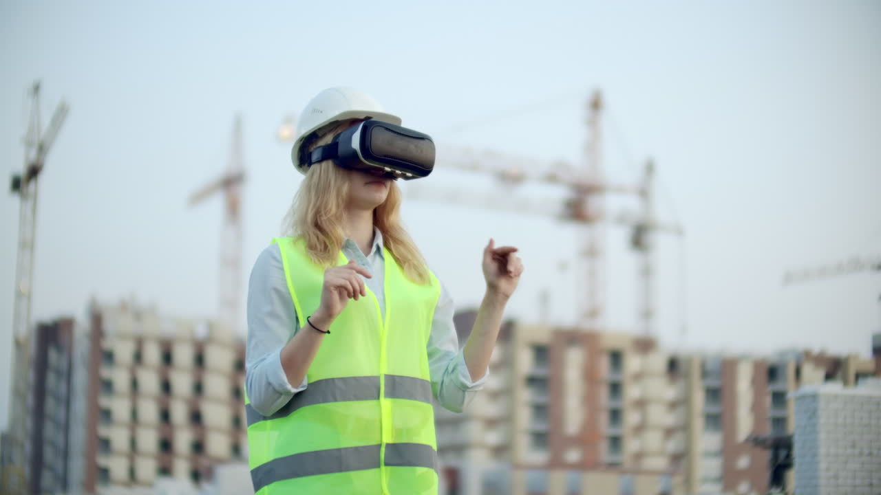 retrato de una inspectora analizando el trabajo de los constructores usando gafas de realidad virtual. una mujer con un casco y un chaleco protector se para en gafas vr y mueve las manos