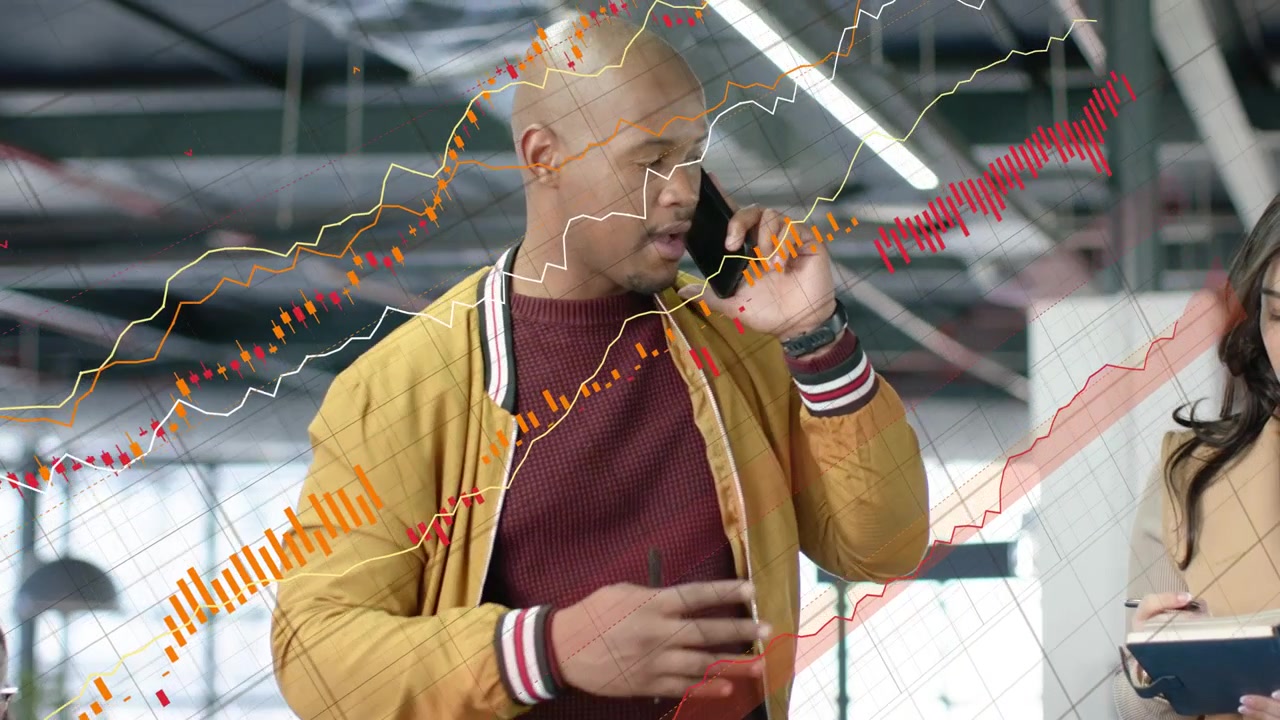 Lead taking call pointing to screen aligning notes, biz charts growing over screens guiding team