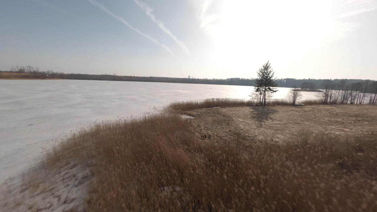 Winter drone footage of icy lake shoreline in Mazury