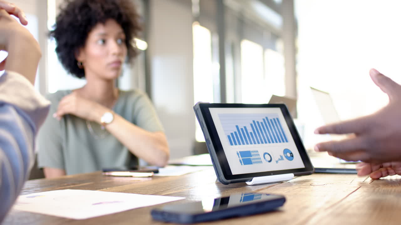 Business colleagues brainstorming ideas while reviewing data on a tablet