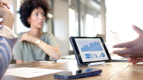 business colleagues brainstorming ideas while reviewing data on a tablet