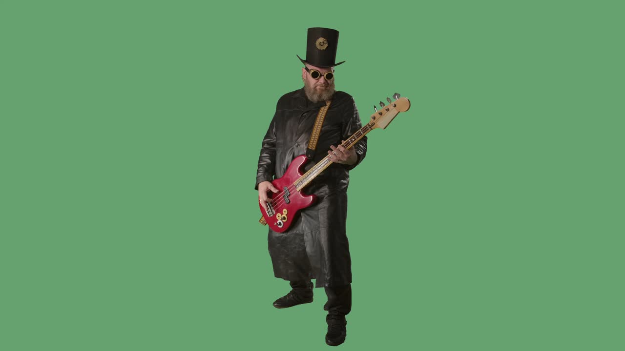 un hombre barbudo con un largo abrigo de cuero, un sombrero de estilo irlandés y gafas originales toca la guitarra roja. un músico de rock toca el bajo en el estudio en pantalla verde con tecla de croma. cámara lenta