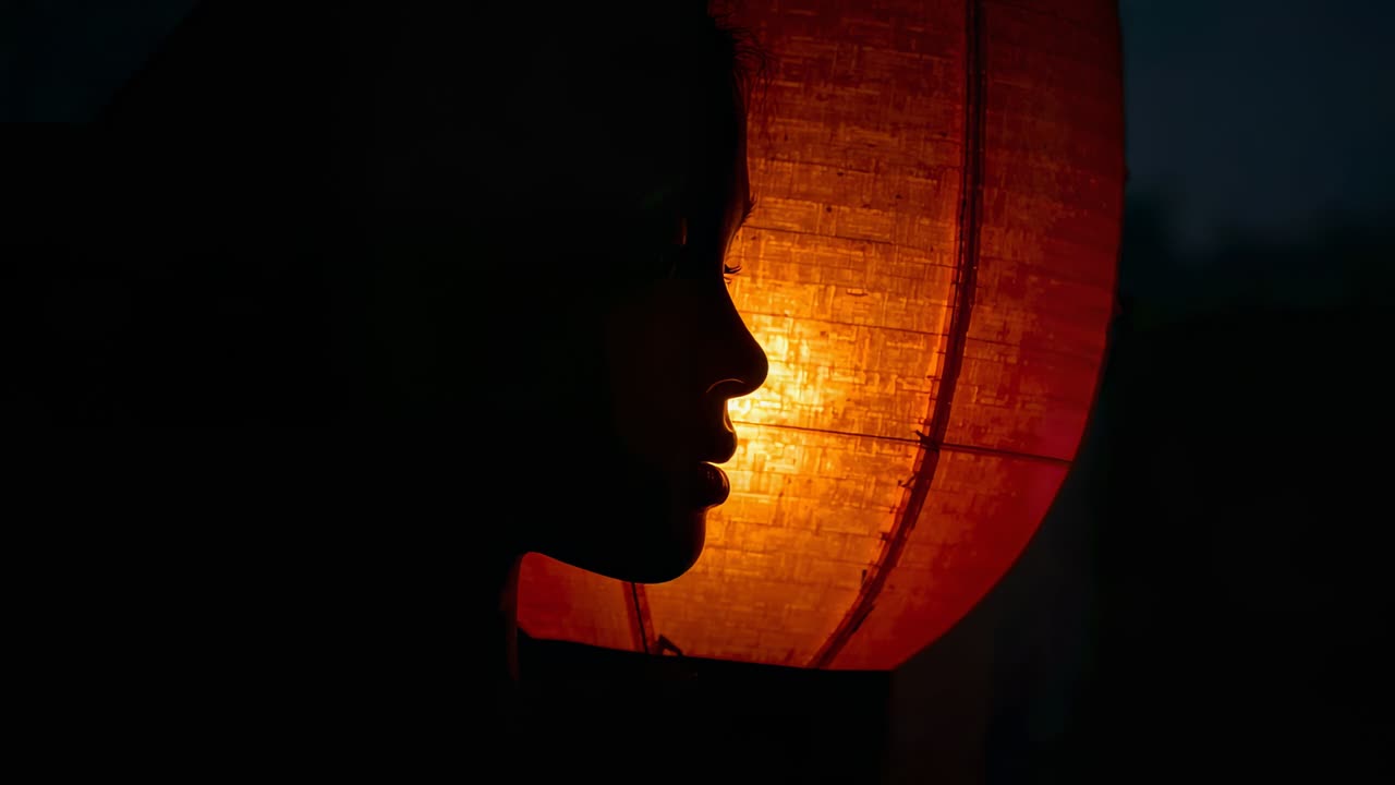 Shifting lantern light teen turning gaze in dim room catching glow with strapless top, copy space